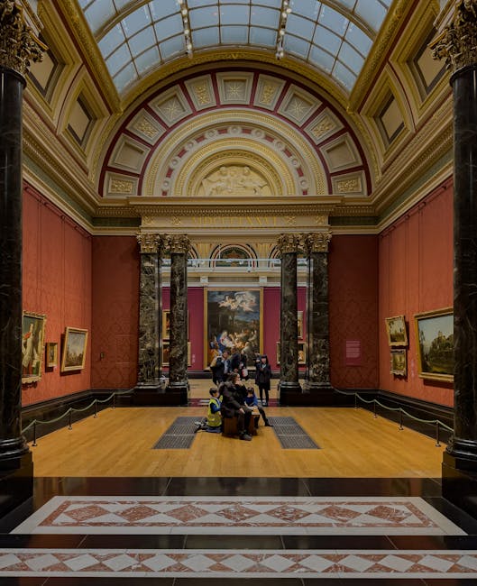 The image depicts the interior of a grand art gallery within the Tate Britain, featuring high domed glass ceilings with ornate decorative moldings and a central skylight. The gallery walls are painted